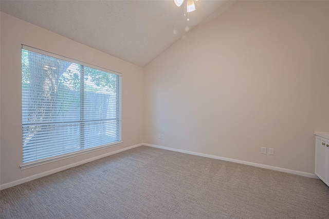 carpeted spare room with ceiling fan, lofted ceiling, and baseboards