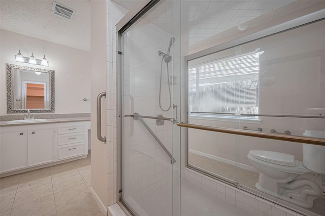 bathroom featuring toilet, tile patterned floors, a stall shower, and vanity