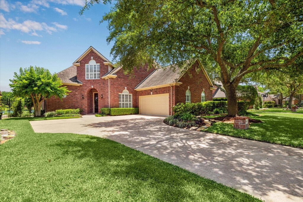 418 Brook Shore Ct, Sugar Land, TX 77478 - traditional home featuring brick siding, an attached garage, concrete driveway, a front yard, and roof with shingles