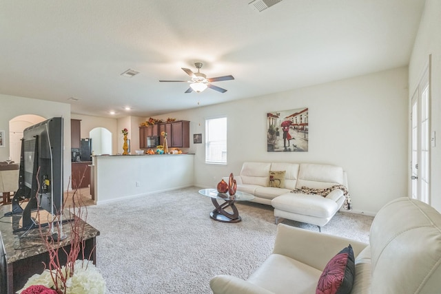 9526 Opal Gates Dr, Rosharon, TX 77583 - living area featuring light carpet, arched walkways, ceiling fan, and baseboards