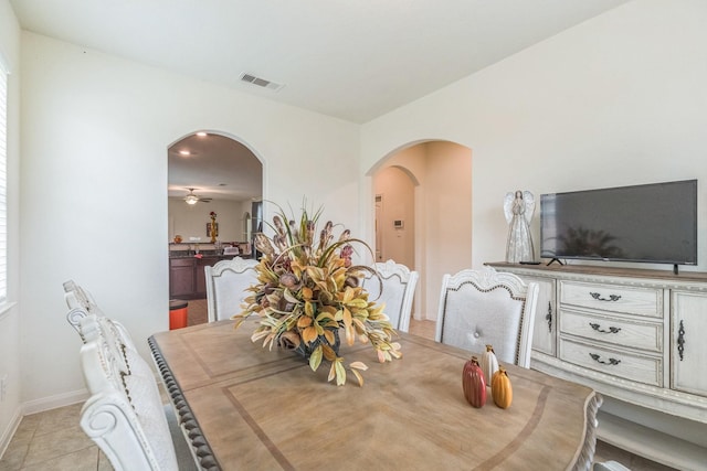 9526 Opal Gates Dr, Rosharon, TX 77583 - dining space with arched walkways, baseboards, light tile patterned floors, and a ceiling fan