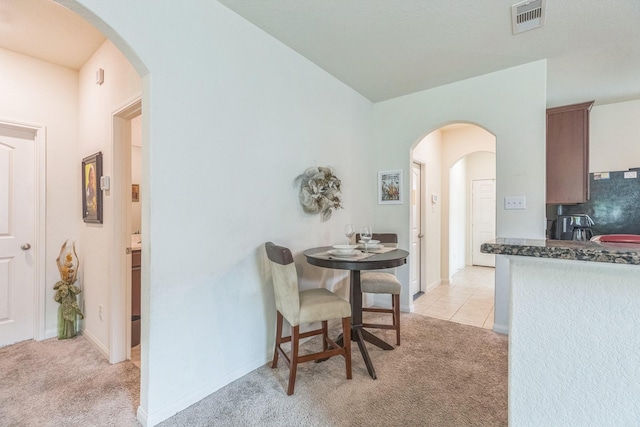 9526 Opal Gates Dr, Rosharon, TX 77583 - dining area with light carpet, arched walkways, and light tile patterned floors