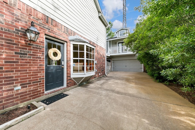 4510 Hazelton St, Houston, TX 77035 - view of exterior entry featuring brick siding, driveway, an attached garage, and a balcony