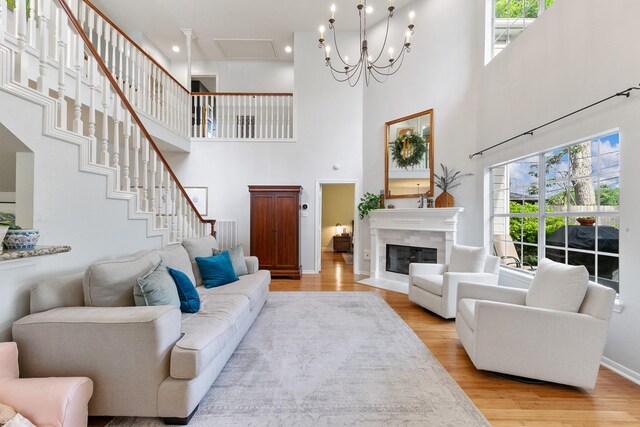 4510 Hazelton St, Houston, TX 77035 - living area with a towering ceiling, light wood-type flooring, a high end fireplace, baseboards, and stairway
