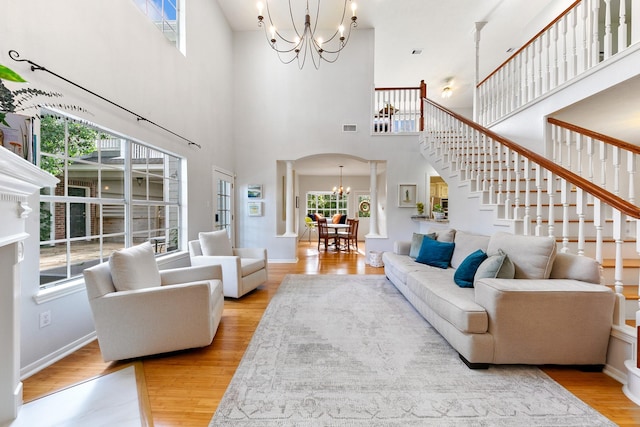 4510 Hazelton St, Houston, TX 77035 - living area featuring a chandelier, arched walkways, stairway, wood finished floors, and a towering ceiling