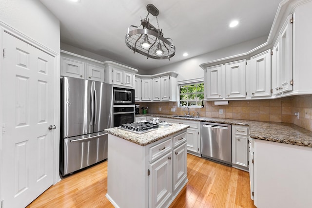 4510 Hazelton St, Houston, TX 77035 - kitchen with appliances with stainless steel finishes, a sink, a center island, light wood-style floors, and recessed lighting