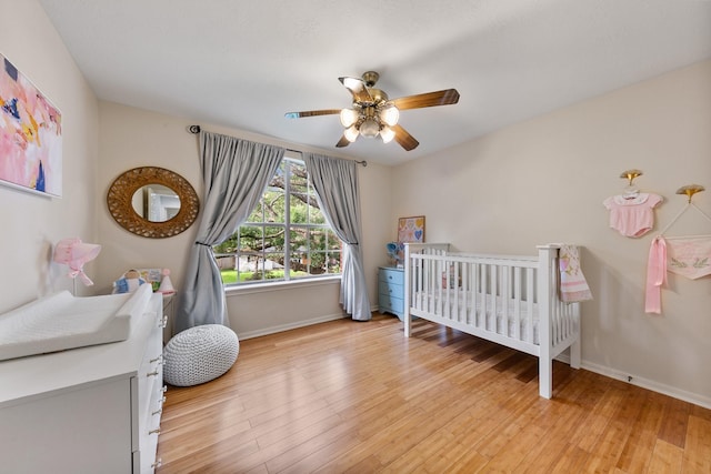 4510 Hazelton St, Houston, TX 77035 - bedroom with baseboards, light wood finished floors, a nursery area, and a ceiling fan