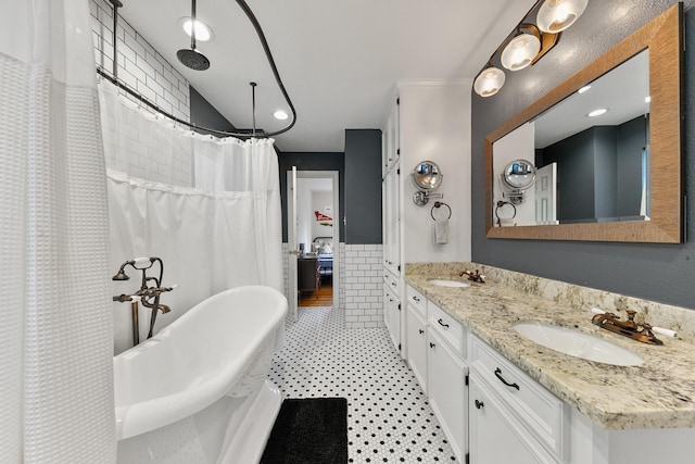 4510 Hazelton St, Houston, TX 77035 - bathroom featuring double vanity, a freestanding tub, a shower with curtain, wainscoting, and tile walls