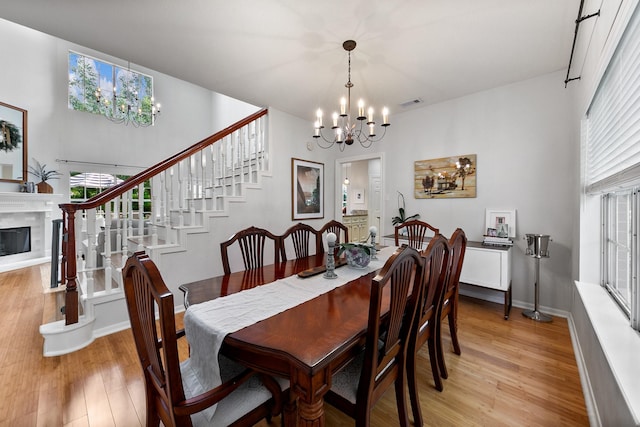 4510 Hazelton St, Houston, TX 77035 - dining space with a chandelier, light wood-style floors, stairs, and a high end fireplace