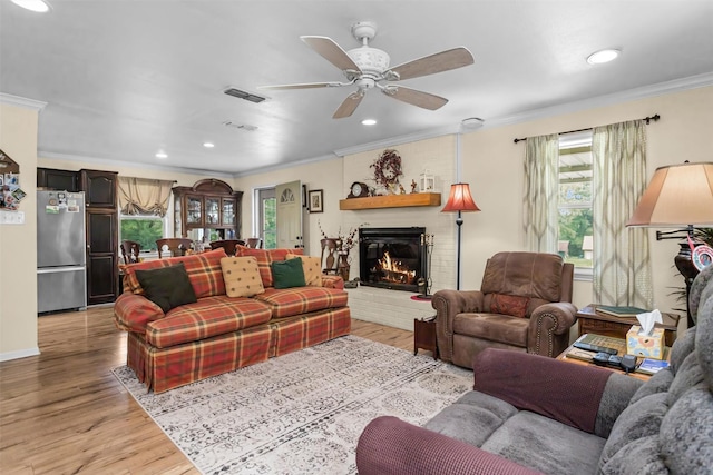 19769 State Highway 21 E, Grapeland, TX 75844 - living room featuring ornamental molding, light wood finished floors, ceiling fan, a brick fireplace, and recessed lighting