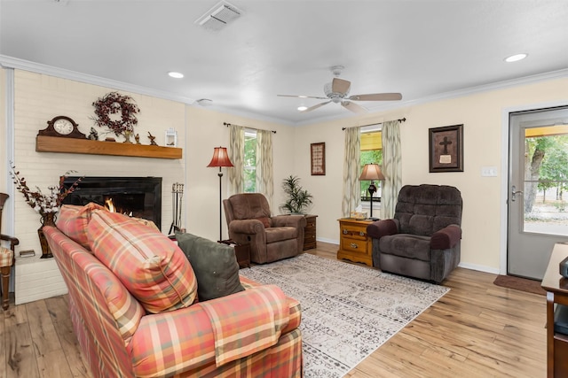 19769 State Highway 21 E, Grapeland, TX 75844 - living area featuring plenty of natural light, crown molding, a ceiling fan, light wood finished floors, and a large fireplace