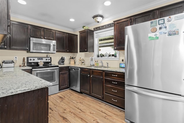 19769 State Highway 21 E, Grapeland, TX 75844 - kitchen featuring stainless steel appliances, a sink, ornamental molding, light wood-style floors, and dark brown cabinets