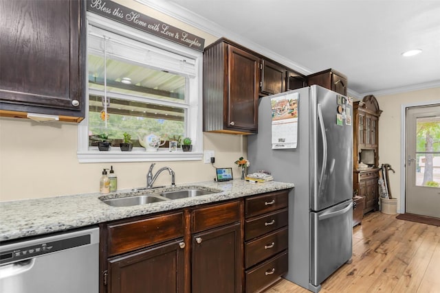 19769 State Highway 21 E, Grapeland, TX 75844 - kitchen with stainless steel appliances, ornamental molding, light wood-style flooring, dark brown cabinets, and light stone counters