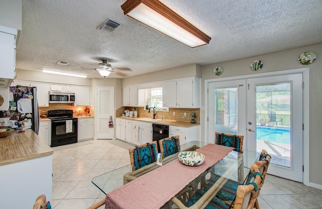 12211 3rd St, Santa Fe, TX 77510 - kitchen with black appliances, a sink, a textured ceiling, french doors, and light countertops