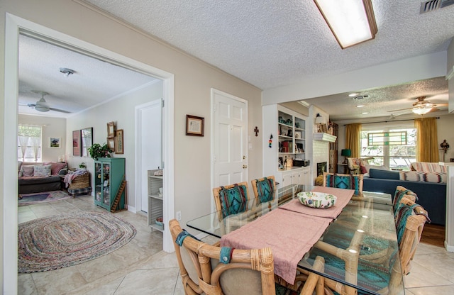 12211 3rd St, Santa Fe, TX 77510 - dining room with ceiling fan, a textured ceiling, plenty of natural light, ornamental molding, and light tile patterned floors