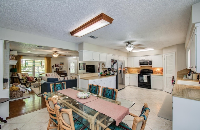 12211 3rd St, Santa Fe, TX 77510 - dining room with a ceiling fan, light tile patterned flooring, and a textured ceiling