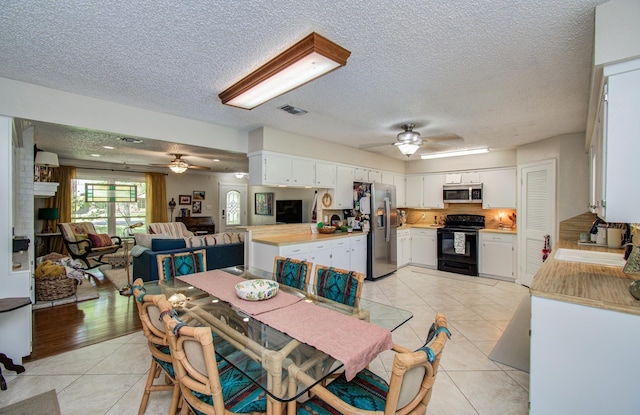 12211 3rd St, Santa Fe, TX 77510 - dining space with a ceiling fan, light tile patterned floors, and a textured ceiling
