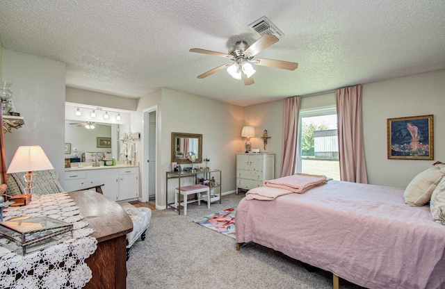 12211 3rd St, Santa Fe, TX 77510 - bedroom featuring a textured ceiling, light colored carpet, connected bathroom, a ceiling fan, and baseboards