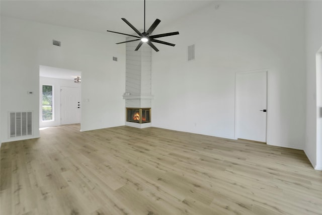 964 Lake View Dr, Montgomery, TX 77356 - unfurnished living room featuring high vaulted ceiling, light wood-type flooring, a fireplace, and a ceiling fan