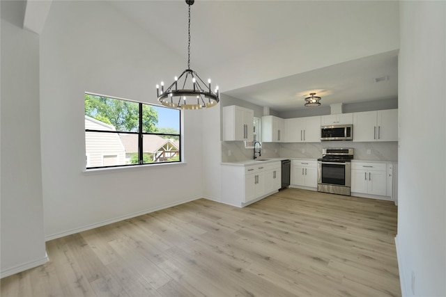964 Lake View Dr, Montgomery, TX 77356 - kitchen with appliances with stainless steel finishes, a sink, light countertops, light wood finished floors, and vaulted ceiling