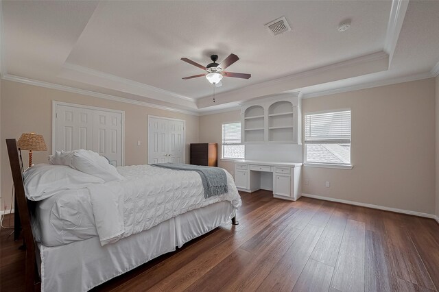 5807 Juniper Knoll Ln, Houston, TX 77345 - bedroom featuring a tray ceiling, hardwood / wood-style floors, two closets, baseboards, and ornamental molding