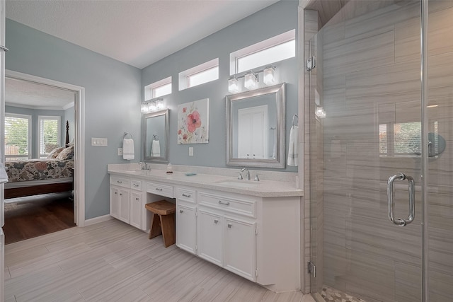 5807 Juniper Knoll Ln, Houston, TX 77345 - ensuite bathroom featuring double vanity, a stall shower, and baseboards