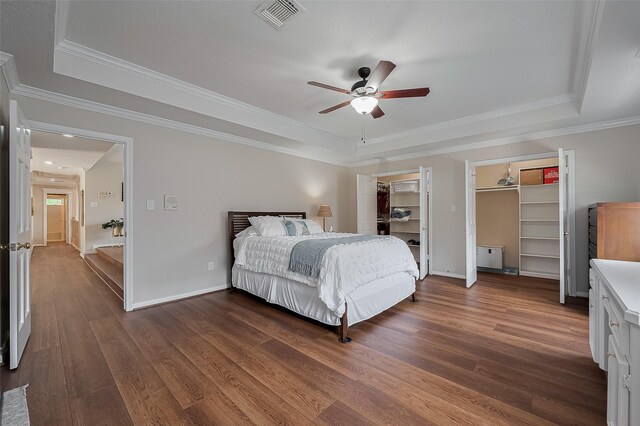 5807 Juniper Knoll Ln, Houston, TX 77345 - bedroom featuring a tray ceiling, wood finished floors, crown molding, baseboards, and ceiling fan