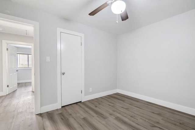 207 W Saunders St, League City, TX 77573 - unfurnished bedroom with wood finished floors, baseboards, and a ceiling fan
