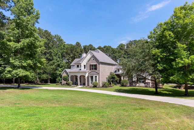 15557 Crown Oaks Dr, Montgomery, TX 77316 - view of front facade featuring a front lawn, stone siding, and a chimney