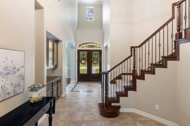 15557 Crown Oaks Dr, Montgomery, TX 77316 - entryway with a high ceiling, stairs, arched walkways, and baseboards