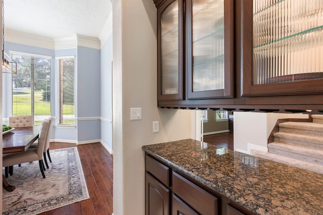 15557 Crown Oaks Dr, Montgomery, TX 77316 - kitchen featuring dark wood-style floors, glass insert cabinets, baseboards, ornamental molding, and dark stone countertops