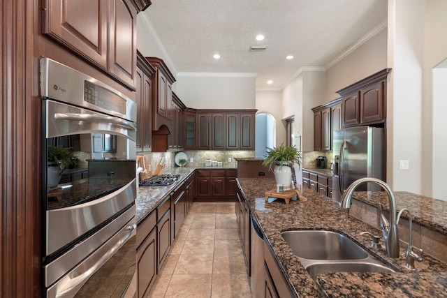 15557 Crown Oaks Dr, Montgomery, TX 77316 - kitchen with appliances with stainless steel finishes, a sink, tasteful backsplash, ornamental molding, and dark stone countertops