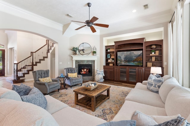 15557 Crown Oaks Dr, Montgomery, TX 77316 - living area featuring ceiling fan, crown molding, stairs, arched walkways, and a high end fireplace