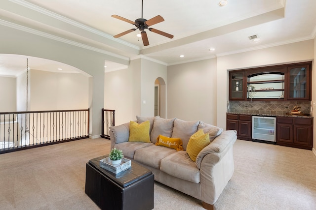 15557 Crown Oaks Dr, Montgomery, TX 77316 - living room with wine cooler, light carpet, arched walkways, ceiling fan, and bar