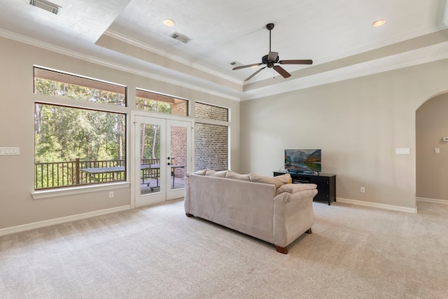 15557 Crown Oaks Dr, Montgomery, TX 77316 - living area with crown molding, a raised ceiling, french doors, arched walkways, and light colored carpet