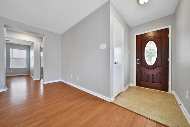 foyer entrance with baseboards and light wood-type flooring