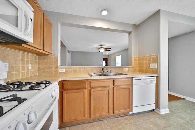 kitchen with white appliances, a sink, light countertops, ceiling fan, and decorative backsplash