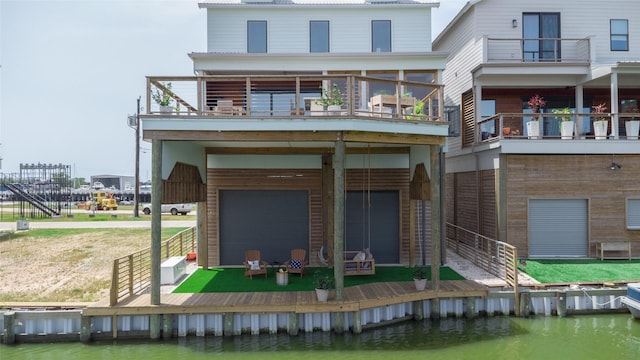 29 Cmdr Runco Ln, Taylor Lake Village, TX 77586 - back of house with a balcony, a garage, and a deck with water view