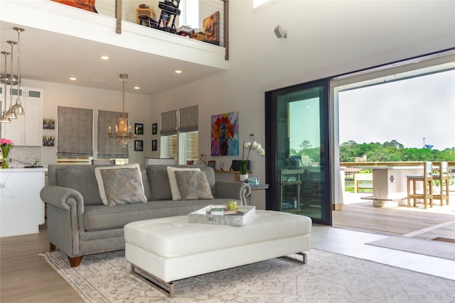 29 Cmdr Runco Ln, Taylor Lake Village, TX 77586 - living area featuring a chandelier, light wood-style floors, recessed lighting, and a towering ceiling