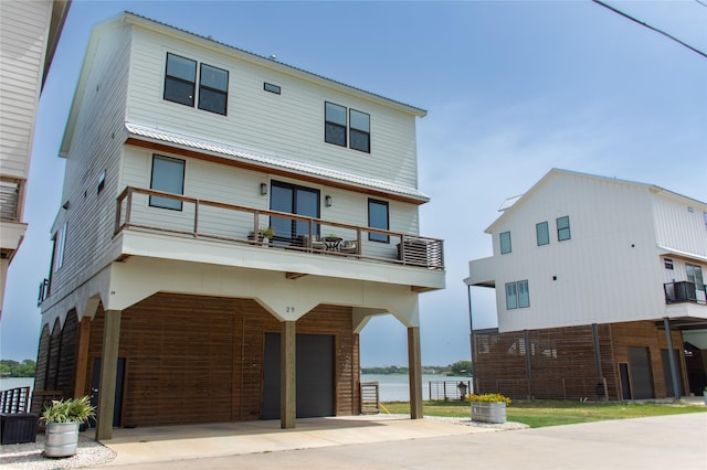 29 Cmdr Runco Ln, Taylor Lake Village, TX 77586 - view of front facade featuring a garage, a balcony, driveway, a water view, and cooling unit