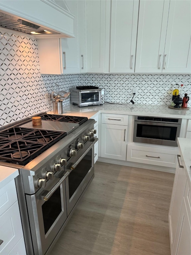 29 Cmdr Runco Ln, Taylor Lake Village, TX 77586 - kitchen with double oven range, custom range hood, light countertops, and tasteful backsplash