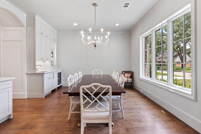 dining room featuring a chandelier, wood finished floors, crown molding, baseboards, and recessed lighting