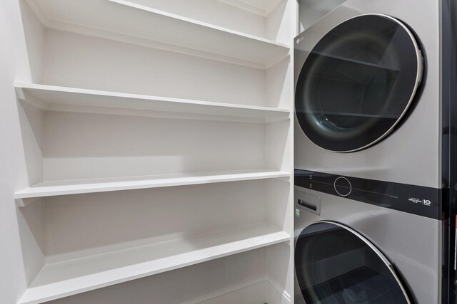 clothes washing area featuring stacked washer and clothes dryer