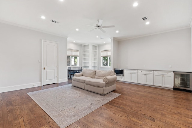 living room featuring wine cooler, ornamental molding, a ceiling fan, recessed lighting, and dark wood-style floors