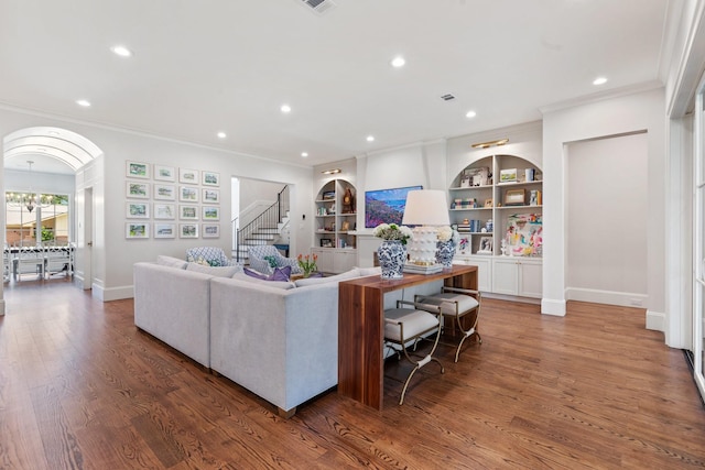 living area featuring ornamental molding, recessed lighting, stairway, wood finished floors, and built in features