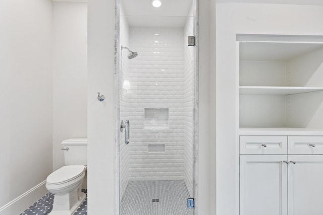 bathroom with a shower stall, toilet, baseboards, and recessed lighting