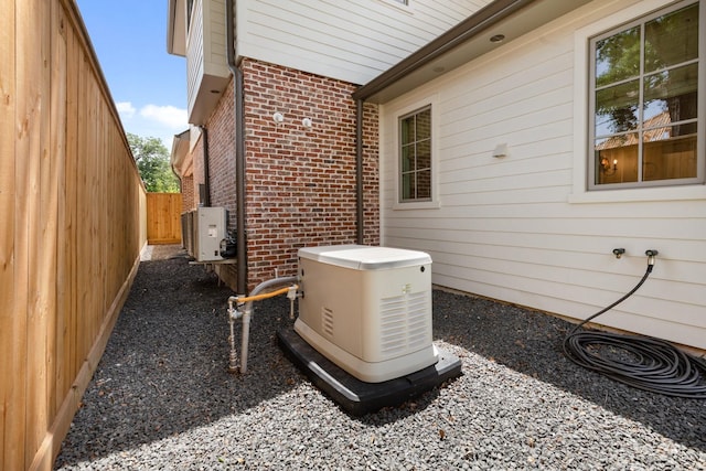 exterior view of a power unit, brick siding, a cooling unit, and fence