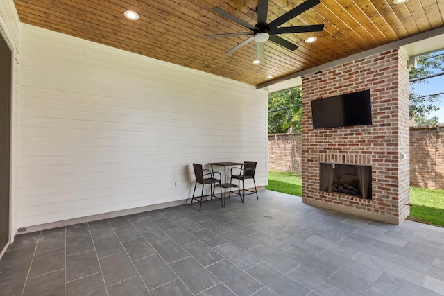 view of patio / terrace with an outdoor brick fireplace and ceiling fan