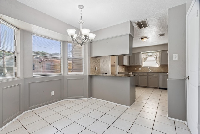 15623 Ensenada Dr, Houston, TX 77083 - kitchen with stainless steel dishwasher, light tile patterned floors, a sink, decorative backsplash, and a chandelier