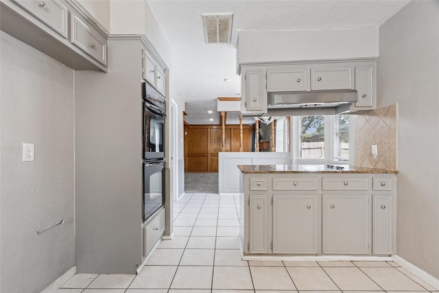 15623 Ensenada Dr, Houston, TX 77083 - kitchen featuring light tile patterned floors, a peninsula, baseboards, and backsplash